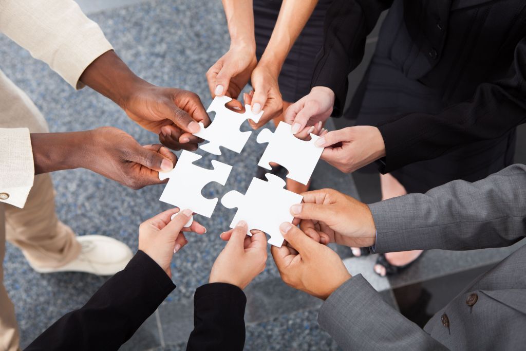 Close-up Photo Of Businesspeople Holding Jigsaw Puzzle